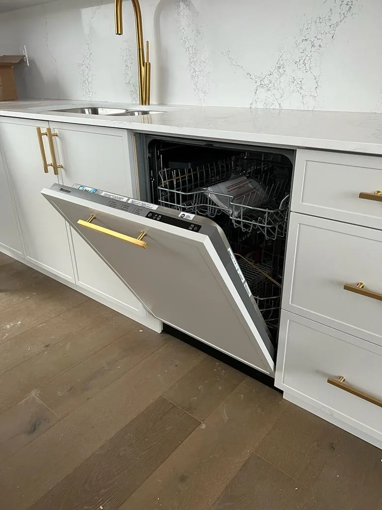 Built-in dishwasher installation in white kitchen cabinetry