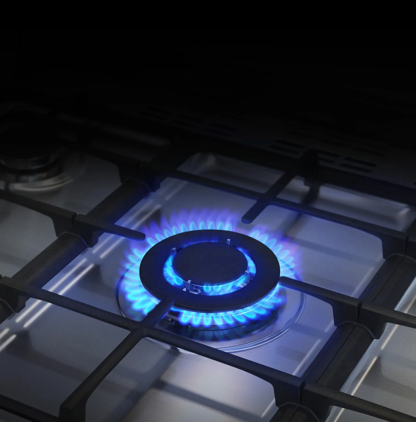 Blue flames burning on a gas range stovetop burner